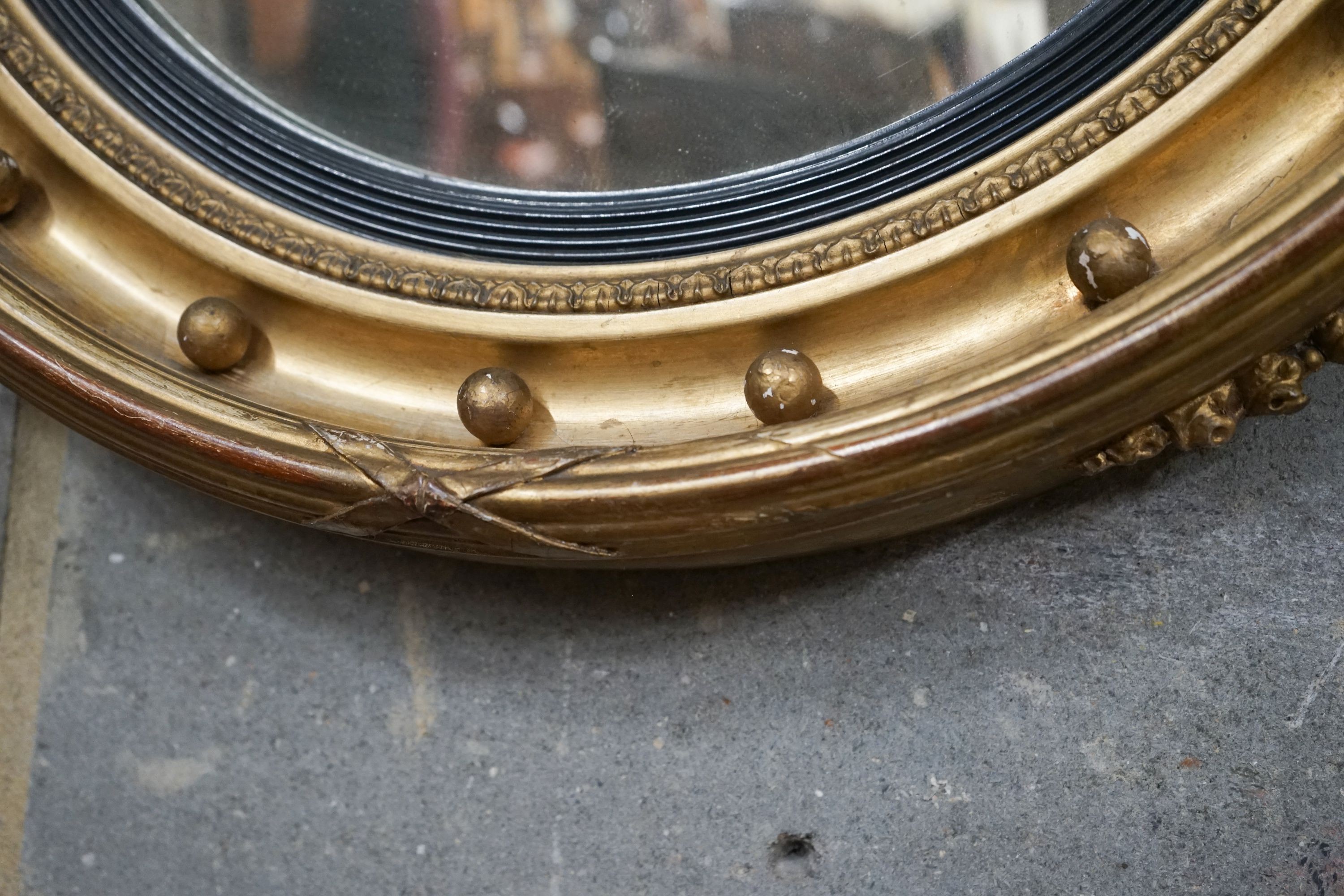 A Regency giltwood and gesso convex wall mirror with eagle pediment, width 60cm, height 94cm